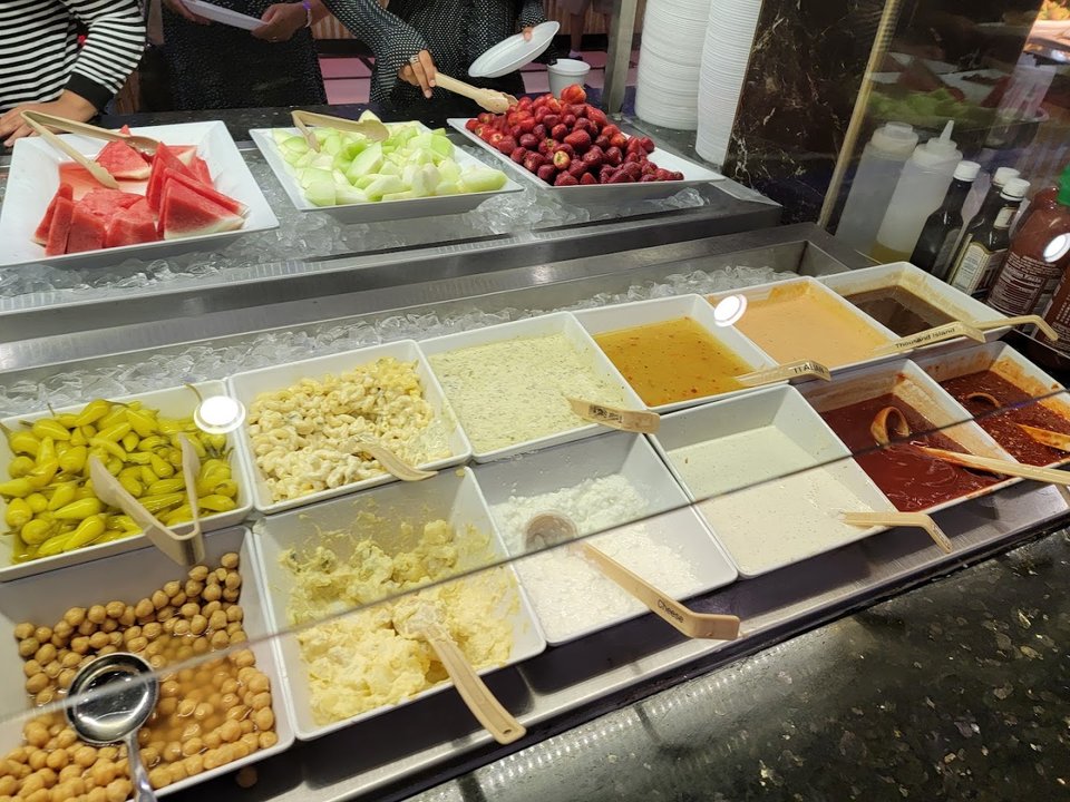 Warm buffet counter with meats and salads.
